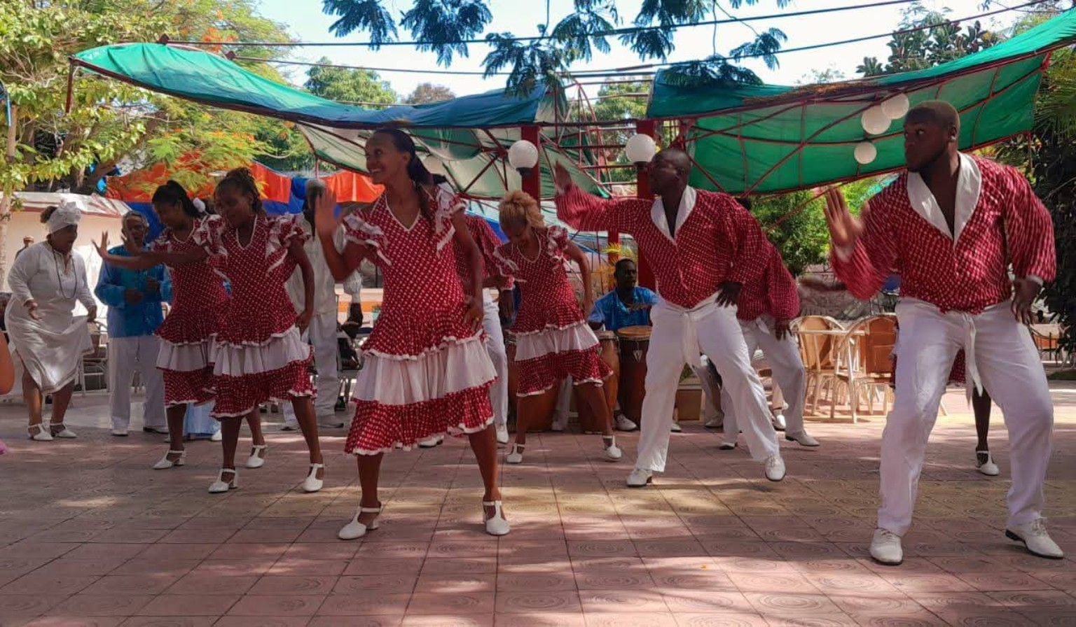 Folklórico Cutumba dancers performing outdoors in red and white costumes