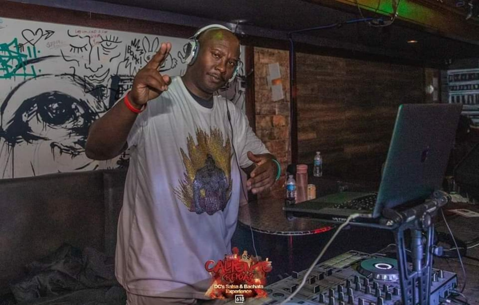 DJ Timba Titan, Cedric Teamer, wearing headphones beside his DJ equipment
