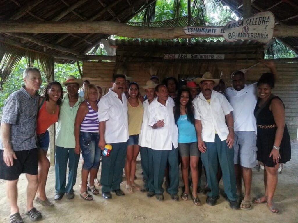 Integrantes de la comunidad y visitantes de DC Casineros en una fotografía de grupo bajo un techo de guano en Baracoa