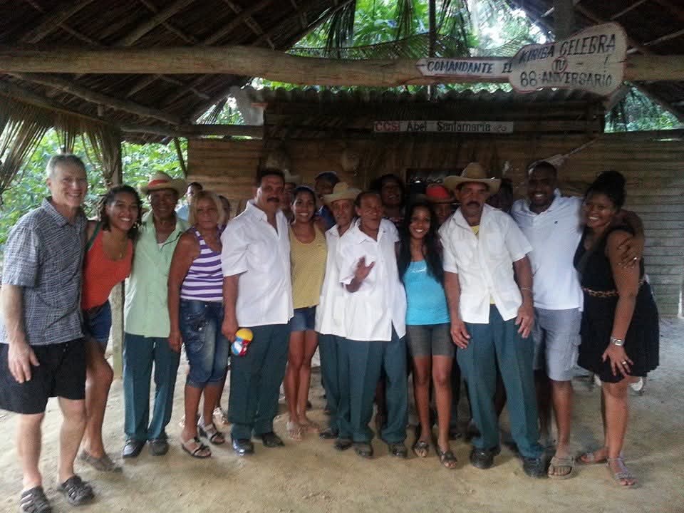 Community members and DC Casineros visitors gathered under a thatched roof in Baracoa