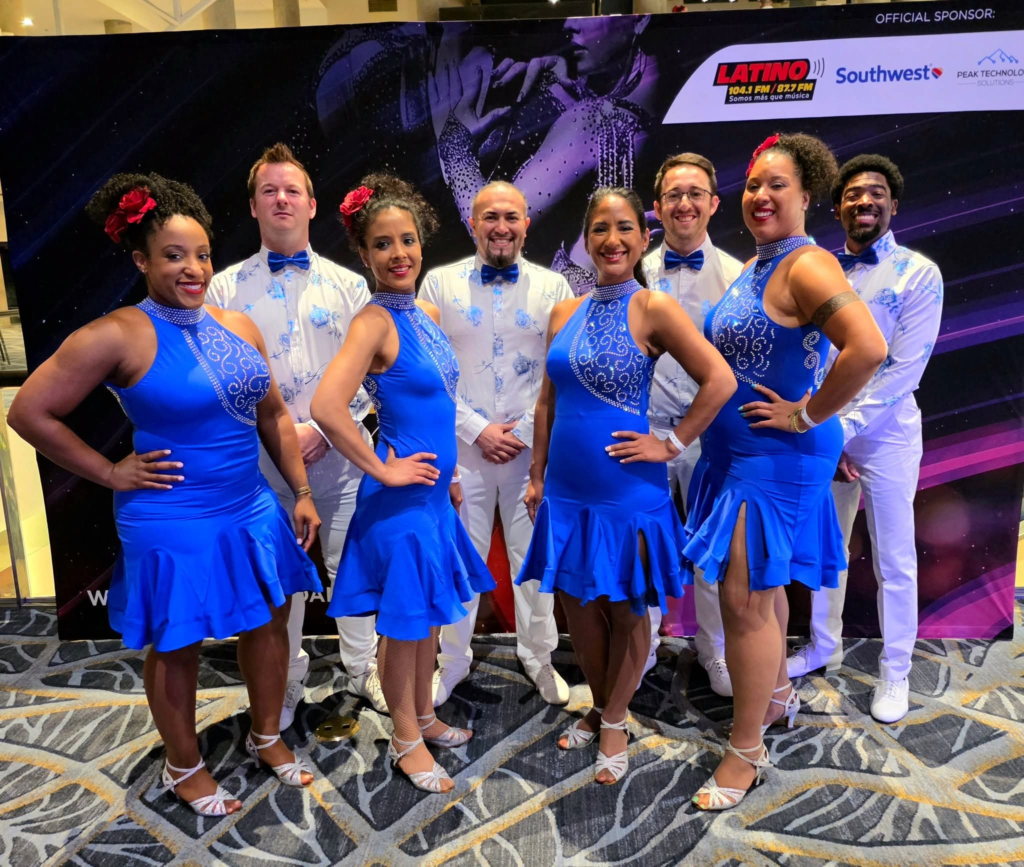 Eight DC Casineros dancers posing in coordinated blue and white costumes