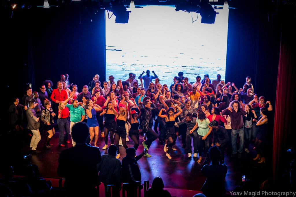 Dancers and audience members celebrating together on a theater stage