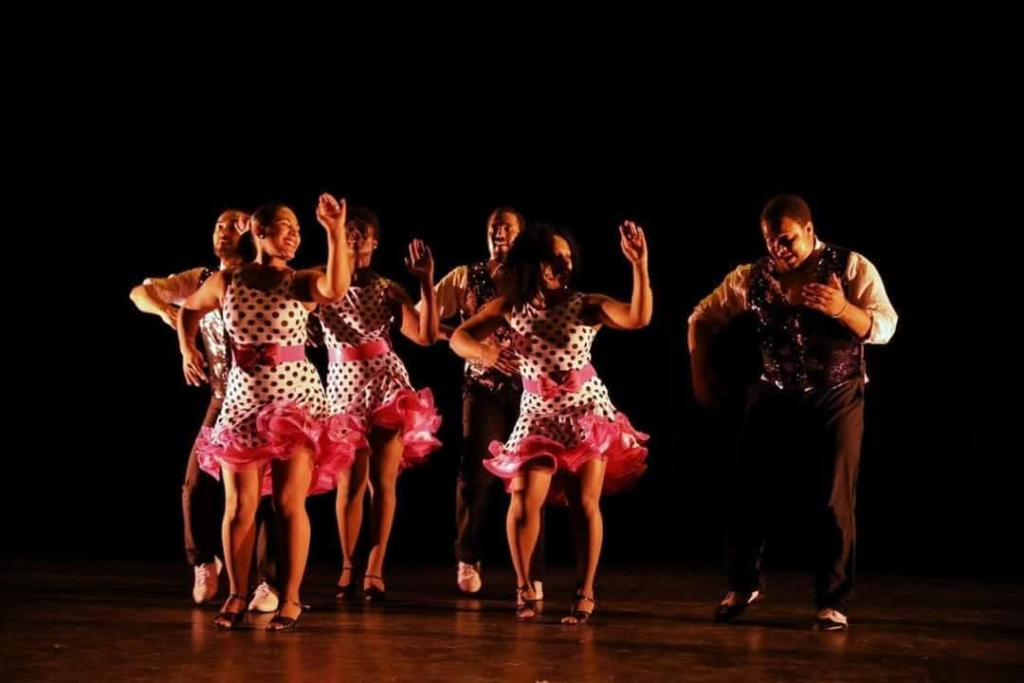 DC Casineros ensemble performing on stage in polka dot dresses with pink ruffles