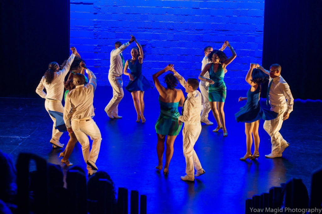 DC Casineros dancers performing together at Dance Place, with blue stage lighting
