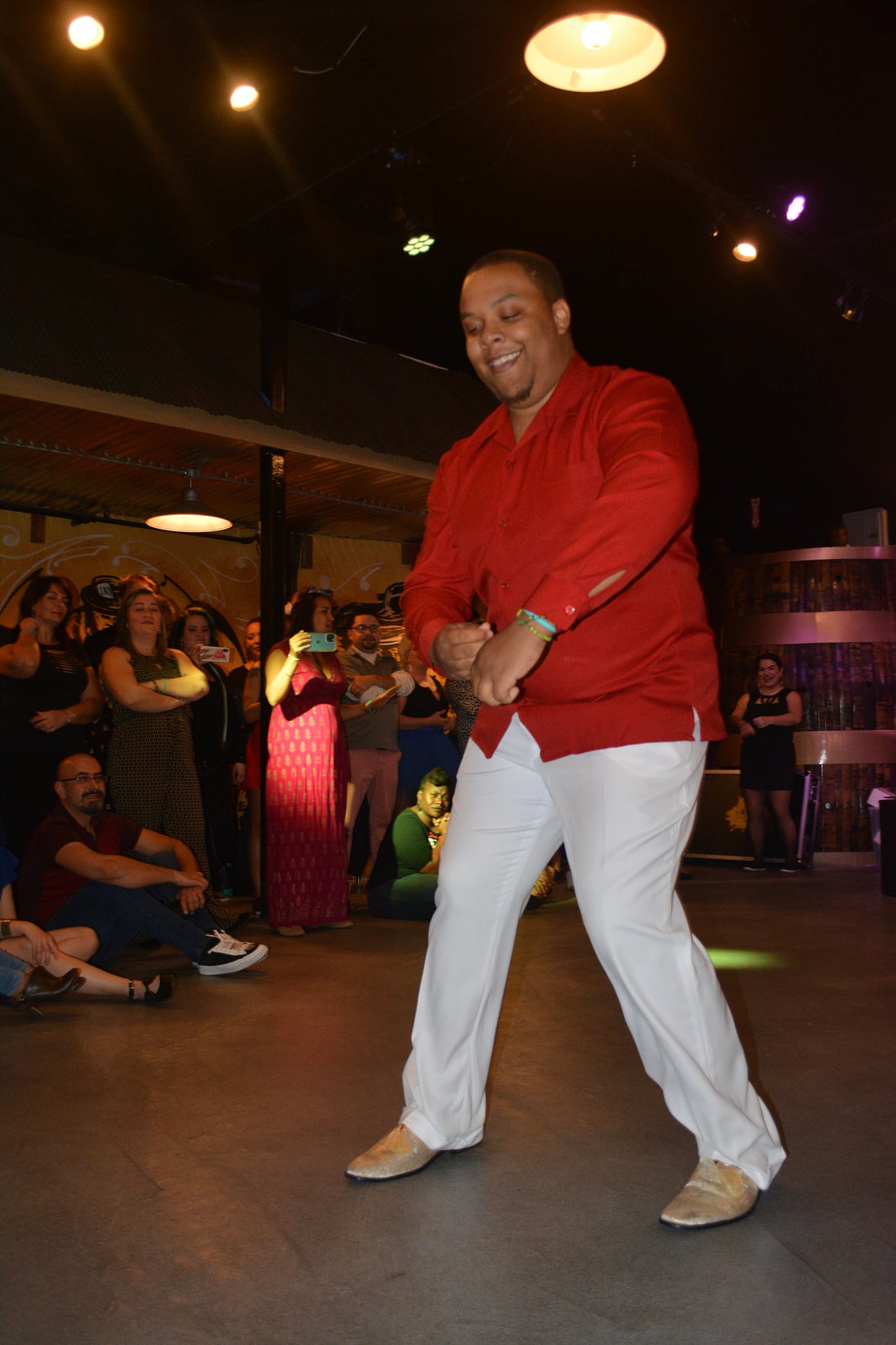 Jonathan Burke dancing in a red shirt and white trousers