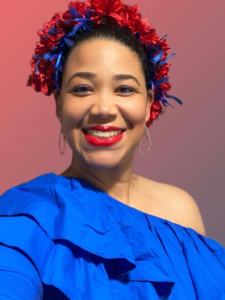 Lisa Berroa, DC Casineros instructor, wearing blue with red and blue flowers in her hair.
